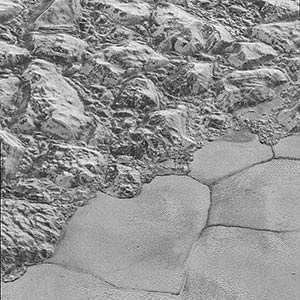 Mountains of ice along a portion of smoother ice planes on Pluto’s surface.